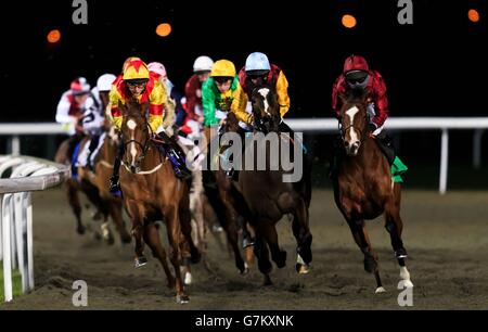 Runner e piloti girano la curva nelle prime fasi della 32Red sull'App Store Median Auction Maiden Stakes all'ippodromo di Kempton Park, Middlesex. Foto Stock