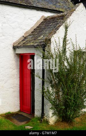 Tipici cottage scozzese con porta rossa e spiovente del tetto di ardesia nel Parco nazionale di Cairngorms Foto Stock