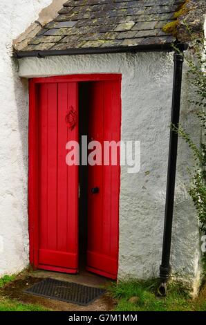 Tipici cottage scozzese con porta rossa e spiovente del tetto di ardesia nel Parco nazionale di Cairngorms Foto Stock