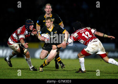 Josh Lewsey (centro) di London Wasps attraversa gli attacchi di Alex Brown (a sinistra) e Henry Paul (a destra) di Gloucester. Foto Stock