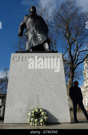 Fiori deposti dalla famiglia del defunto primo Ministro Sir Winston Churchill alla sua statua in Piazza del Parlamento a Londra per celebrare il 50 ° anniversario dei suoi funerali. Foto Stock