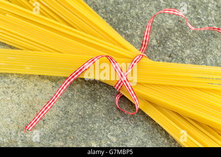 Non cotti gli spaghetti con le verdure un tavolo in pietra Foto Stock