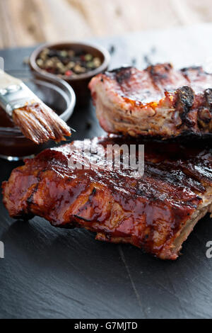 Carne di maiale alla griglia baby nervature con BBQ SAUCE Foto Stock