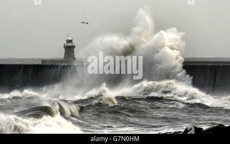 Le onde colpiscono il muro del molo sul lungomare di Tynemouth, sulla costa nord-orientale. Foto Stock