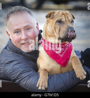 NOTA IL RACCOLTO ALTERNATIVO Kai il cane con il suo nuovo proprietario Ian Russell in un ufficio scozzese SPCA a Glasgow, dopo essere stato abbandonato in una stazione ferroviaria con una valigia piena dei suoi effetti personali. Foto Stock