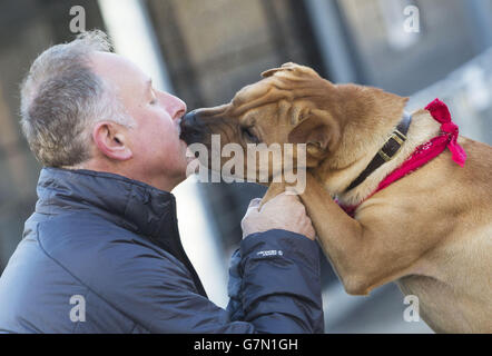 Kai il cane con il suo nuovo proprietario Ian Russell presso un ufficio scozzese SPCA a Glasgow, dopo essere stato abbandonato in una stazione ferroviaria con una valigia piena dei suoi beni. Foto Stock