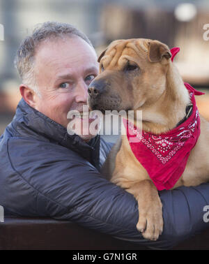 Kai il cane con il suo nuovo proprietario Ian Russell presso un ufficio scozzese SPCA a Glasgow, dopo essere stato abbandonato in una stazione ferroviaria con una valigia piena dei suoi beni. Foto Stock