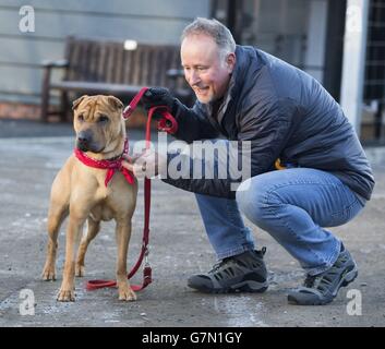 Kai il cane con il suo nuovo proprietario Ian Russell presso un ufficio scozzese SPCA a Glasgow, dopo essere stato abbandonato in una stazione ferroviaria con una valigia piena dei suoi beni. Foto Stock