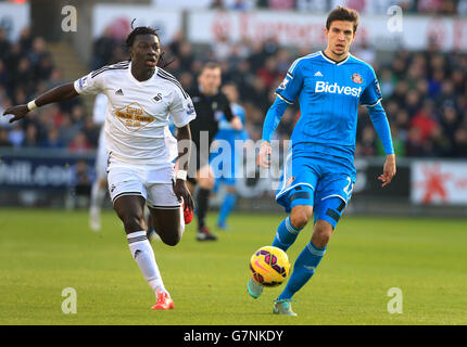 Santiago Vergini di Sunderland difende il pallone dal Bafetimbi Gomis (a sinistra) di Swansea City durante la partita della Barclays Premier League al Liberty Stadium di Swansea. Foto Stock