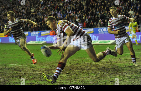 Joe Burgess di Wigan Warriors va oltre per la seconda prova della sua squadra, per legare la partita a 12-12 durante la partita della World Club Series al DW Stadium, Wigan. Foto Stock