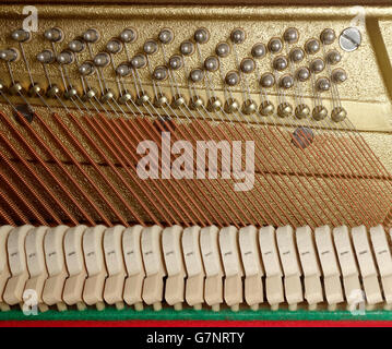 Chiusura del meccanismo di azione su un pianoforte verticale con martelli, bass stringhe, barra a pressione e spine di sintonizzazione Foto Stock