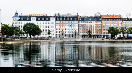 Edifici con neon di insegne pubblicitarie sui tetti accanto al Sortedams Sø, Copenaghen Foto Stock