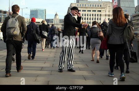 Un attore, vestito come l'uomo di imposta, le mani fuori libero &libbra;5 note sul ponte di Londra per illustrare la ricerca da Santander che mostra che i britannici stanno consegnando &libbra;57 milioni ogni anno all'uomo di imposta inutilmente non approfittando di risparmio esentasse. Foto Stock