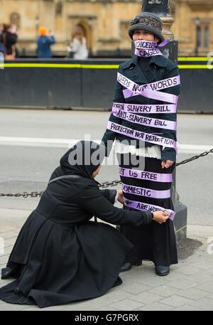 I lavoratori domestici vestiti da suffragette protestano al di fuori della Camera del Parlamento a Westminster, nel centro di Londra, durante la Giornata internazionale della donna, chiedendo un emendamento alla legge sulla schiavitù moderna, che consentirà ai lavoratori domestici di cambiare datore di lavoro una volta nel Regno Unito. Foto Stock