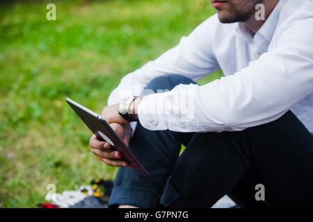 Imprenditore utilizzando Computer tablet nel parco. Close-up shot. Foto Stock