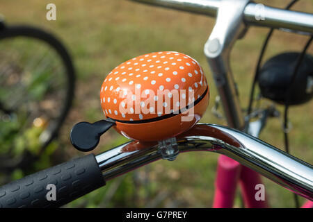 Dettaglio di una bicicletta arancione campanello esterno Foto Stock