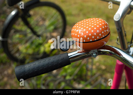 Dettaglio di una bicicletta arancione campanello esterno Foto Stock