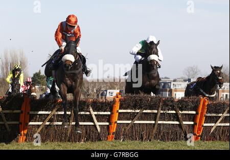 Come De Mee guidato da Sam Twiston- Davies (a sinistra) conduce il campo sull'ultimo volo prima di andare a vincere la 14.00; la E.B.F. William Hill Novices' handicap corsa finale corsa durante la William Hill Imperial Cup Day all'ippodromo di Sandown, Surrey. Foto Stock