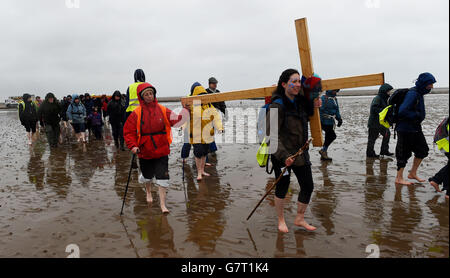 Caroline Wilson (fronte) porta una croce mentre si unisce ai pellegrini che attraversano da Beal Sands alla Santa Isola di Lindisfarne in Northumberland durante il pellegrinaggio cristiano annuale di Pasqua il Venerdì Santo. PREMERE ASSOCIAZIONE foto. Data immagine: Venerdì 3 aprile 2015. Il credito fotografico dovrebbe essere: Owen Humphreys/PA Wire Foto Stock