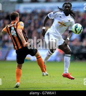 Alex Bruce di Hull City (a sinistra) e il Bafetimbi Gomis di Swansea City in azione durante la partita della Barclays Premier League al Liberty Stadium di Swansea. Foto Stock