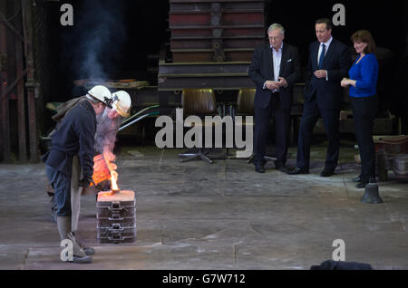 Il primo ministro David Cameron è esposto intorno alla John Taylor Bell Foundry a Loughborough, la più grande fonderia di campane del mondo, con il candidato locale e il segretario per l'istruzione Nicky Morgan, dove ha visto una campana essere gettata. Foto Stock