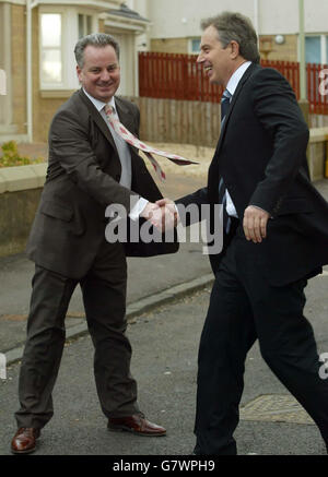 Il primo ministro Tony Blair stringe le mani con il primo ministro scozzese Jack McConnell durante una visita alla casa di famiglia Duff, parte di un progetto di associazione di alloggi a Dundee. Foto Stock