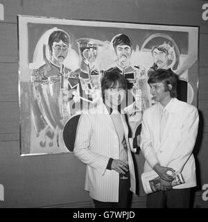 Bespectacled JOHN LENNON dei Beatles con JONATHAN HAGUE, artista di 21 anni di Llandudno, visto contro una foto dei Beatles, l'opera di Jonathan, in una mostra del suo lavoro che ha aperto alla Royal Institute Galleries di Londra oggi (Lunedi). I Beatles John Lennon e Paul McCartney hanno sponsorizzato la mostra perché Jonathan (Jon) era loro amico. Ha frequentato lo stesso Liverpool College of Art come John Lennon per tre anni. I suoi dipinti sono grandi, colorati, fondamentalmente figurativi e altamente originali. Foto Stock