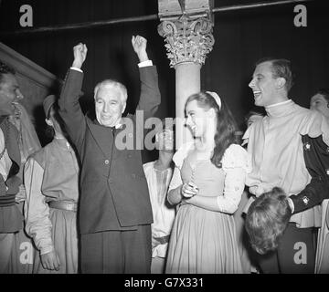 Charlie Chaplin alza le braccia in omaggio alla folla di Old Vic, mentre si trova accanto all'attrice Claire Bloom sul palco del teatro a Waterloo Road, Londra, dove ha visto la sua signora leader 'in altezza' in una rappresentazione di 'Romeo and Juliet' di Shakespeare. Foto Stock