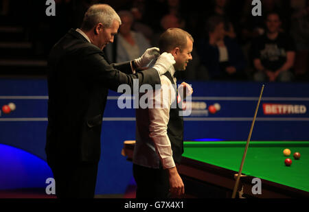 Barry Hawkins, in Inghilterra, è stato regolato da Jan Verhaas durante la sessione di apertura della sua partita semifinale contro Shaun Murphy, in Inghilterra, durante il tredici° giorno dei Campionati Mondiali di Betfred al Crucible Theatre di Sheffield. Foto Stock