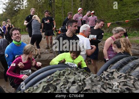 I partecipanti emergono da 'Swer Rat' durante la Tough Mudder London West a Culden FAW a Henley-on-Thames, Oxfordshire. Foto Stock