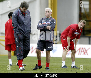 Il direttore del Galles John Toshack (a sinistra) parla con l'allenatore Roy Evans, guardato dall'attaccante Craig Bellamy (a destra). Foto Stock