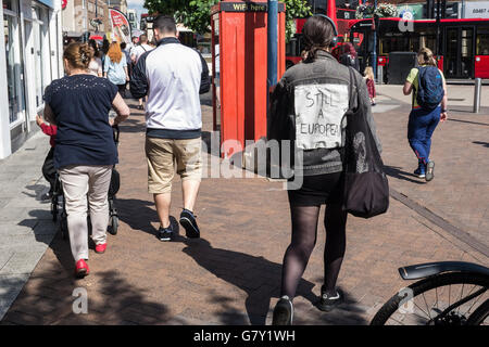 Kingston-upon-Thames, Regno Unito. Il 27 giugno, 2016. Una giovane donna vestita di nero e Jeans Leggings ha segnato un segno in casa sulla sua schiena la lettura "ancora un europeo" come lei cammina attraverso Kingston-upon-Thames shopping center Credito: a Vista/fotografica Alamy Live News Foto Stock