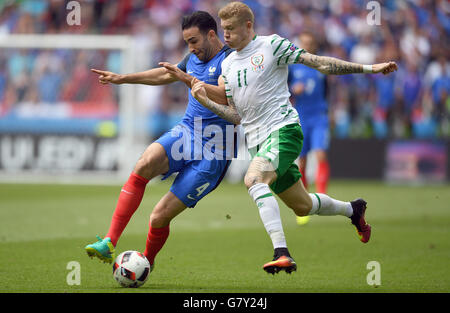 Lione, Francia. Il 26 giugno, 2016. Adil rami (L) della Francia il sistema VIES per la palla con James McClean dell Irlanda durante UEFA EURO 2016 Round di 16 partita di calcio tra Francia e Irlanda allo Stade de Lyon a Lione, Francia, 26 giugno 2016. Foto: Federico Gambarini/dpa/Alamy Live News Foto Stock