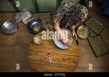 L'Egitto. Il 27 giugno, 2016. Donna egiziana fare biscotti e snack in preparazione per la celebrazione del l'Eid Al Fitr ad un forno di casa al Cairo, Egitto, Lunedì, Giugno, 27, 2016. I mercati e i centri commerciali per lo shopping in Egitto, uno dei più grandi paesi musulmani sono attesi per essere affollate di persone shopping per la celebrazione del 5 luglio che segna la fine del santo mese di digiuno del Ramadan. Prodotti da forno e dolciumi e famiglia è una delle più importanti tradizioni in Egitto per celebrare l'Eid al-Fitr. © Fayed El-Geziry/ZUMA filo/Alamy Live News Foto Stock