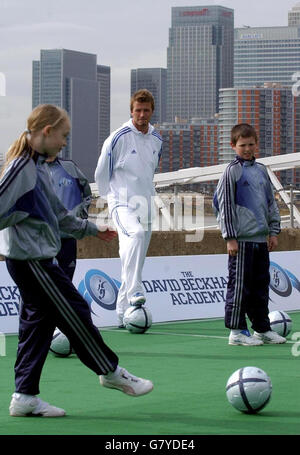 Il calciatore del Real Madrid David Beckham (centro) si affaccia sui bambini che giocano a calcio vicino al Tamigi, per lanciare la sua accademia di calcio per incoraggiare il calcio di base. Foto Stock