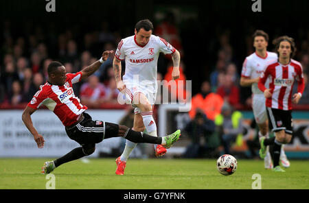 Moses Odubajo di Brentford (a sinistra) e Lee Tomlin di Middlesbrough in azione durante lo Sky Bet Championship, la semifinale Play-Off, prima tappa al Griffin Park, Londra. Foto Stock