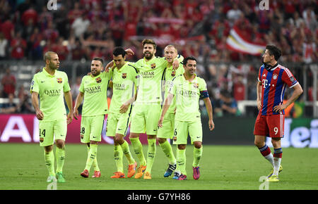 I giocatori di Barcellona festeggiano la vittoria dopo il fischio finale come Bayern Robert Lewandowski di Monaco (a destra) esce dal campo espulso dopo la partita Foto Stock