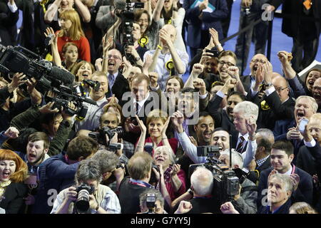 Il leader della SNP Nicola Sturgeon reagisce con i suoi sostenitori dopo aver guardato sul grande schermo i loro guadagni nelle elezioni parlamentari britanniche al conteggio delle elezioni generali per le circoscrizioni di Glasgow all'Emirates Arena di Glasgow. Foto Stock