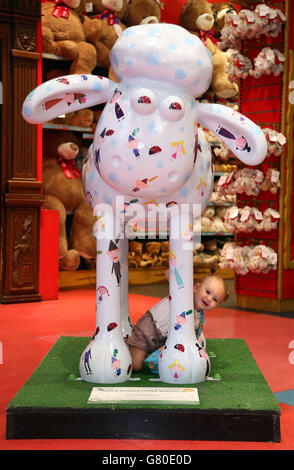 Lilly-Anne Jacobie di 23 mesi da Carshalton, Surrey gioca peek-a-boo con Shaun la pecora durante un evento ospitato da Nutricia per aumentare la consapevolezza della nutrizione medica presso il negozio di giocattoli Hamleys a Londra Regent Street. Foto Stock