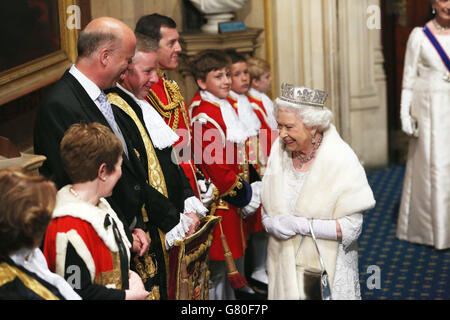 La regina Elisabetta II oltrepassa il segretario alla giustizia e il cancelliere Michael Gove (quarta a sinistra) e il leader della Camera dei Comuni Chris Grayling (terza a sinistra) mentre lascia il portico normanno della Camera dei Comuni al Palazzo di Westminster a Londra, dopo l'apertura di Stato del Parlamento. Foto Stock