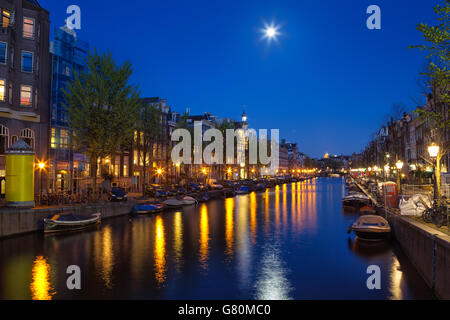 Night Shot della Prinsengracht nel centro di Amsterdam, Paesi Bassi con la luna piena splende e riflettendo nell'acqua. Foto Stock