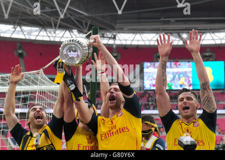 Arsenal's per Mertesacker (seconda a destra) e Olivier Giroud (destra) festeggiano la vittoria alla fine della finale della Coppa fa al Wembley Stadium di Londra. PREMERE ASSOCIAZIONE foto. Data immagine: Sabato 30 maggio 2015. Vedi PA Story SOCCER fa Cup. Il credito fotografico dovrebbe essere: Anthony Devlin/PA Wire. RESTRIZIONI: Massimo 45 immagini durante un confronto. Nessuna emulazione video o promozione come "live". Nessun utilizzo in giochi, concorsi, merchandising, scommesse o servizi di club/giocatore singolo. Nessun utilizzo con audio, video, dati, dispositivi non ufficiali Foto Stock