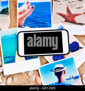 Alta angolazione di una pila di istantanee di spiaggia e mare preso da me e da uno smartphone con schermo vuoto sulla sabbia di un Foto Stock