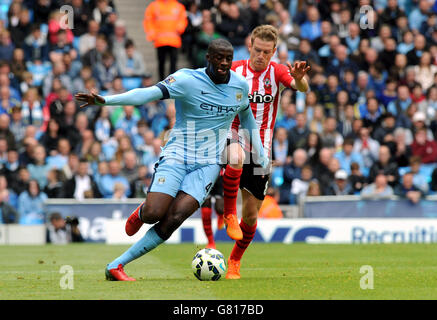 Yaya Toure di Manchester City (a sinistra) e Steven Davis di Southampton combattono per la palla durante la partita della Barclays Premier League all'Etihad Stadium di Manchester. Foto Stock