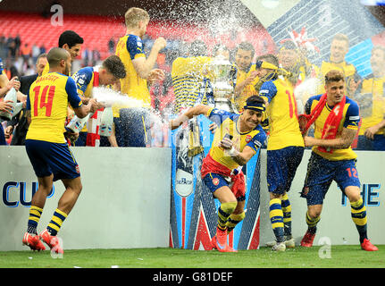 Arsenal's Theo Walcott (a sinistra), Alexis Sanchez (al centro) e Olivier Giroud (a destra) festeggiano con i compagni di squadra dopo aver vinto la fa Cup Foto Stock