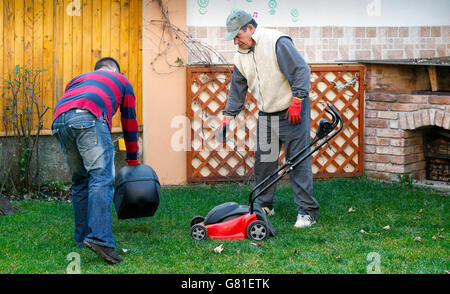 Giovane uomo aiutando senior l uomo è il giardinaggio, attività di uso domestico Foto Stock