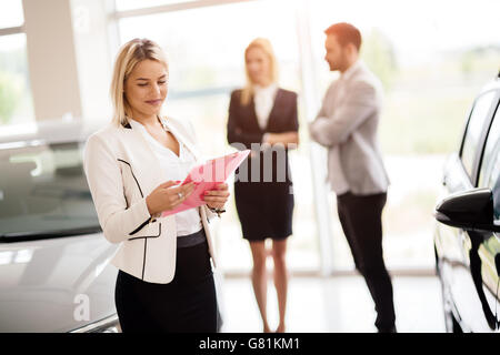 Clienti in cerca di una vettura presso la concessionaria e la personalizzazione di veicolo Foto Stock