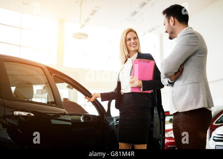 Clienti in cerca di una vettura presso la concessionaria e la personalizzazione di veicolo Foto Stock