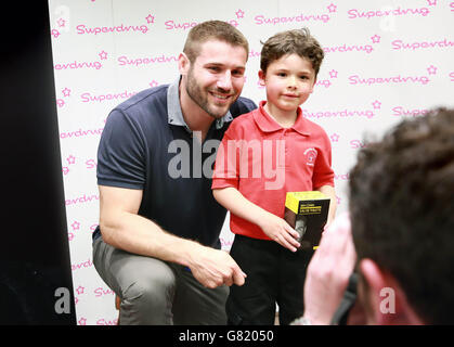 SOLO PER USO EDITORIALE Charlie Nicholson, a 5 anni, da Kettering incontra l'ex inglese e il rugby Union ben Cohen Northampton Saints al lancio della sua fragranza di debutto, ben Cohen for Men al Superdrug di Northampton. Foto Stock