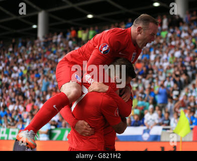 L'inglese Jack Wilshere (al centro) festeggia con il compagno di squadra Adam Lallana (nascosto) e Wayne Rooney (in alto) dopo aver segnato i suoi lati secondo gol della partita durante la partita di qualificazione del Campionato europeo UEFA allo Stozice Stadium, Slovenia. Foto Stock